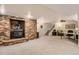 Finished basement with a brick fireplace, carpeted floors, a staircase, and a desk with office chair at 13 Club Ln, Littleton, CO 80123