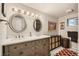 Spacious bathroom with dual sinks, a large vanity, decorative mirrors, and ample storage at 13 Club Ln, Littleton, CO 80123