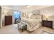 Comfortable bedroom featuring a patterned bedspread, an ottoman, and natural light from a window at 13 Club Ln, Littleton, CO 80123