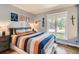 Inviting bedroom with a colorful striped bedspread, hockey-themed wall art, and a large window at 13 Club Ln, Littleton, CO 80123