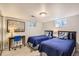 Bedroom with two beds, a small desk with a blue chair, neutral walls, and carpeted floors at 13 Club Ln, Littleton, CO 80123