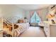 Bedroom featuring a white metal crib, pink accents, and a window with pink curtains overlooking the outdoor scenery at 13 Club Ln, Littleton, CO 80123
