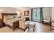Serene bedroom with a comfortable bed, seating area, hardwood floors, and natural light from the window at 13 Club Ln, Littleton, CO 80123