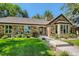 Charming stone home with a tile roof, mature landscaping, and a well-manicured lawn on a sunny day at 13 Club Ln, Littleton, CO 80123