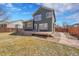 A spacious backyard featuring a deck and a mix of green grass and dormant winter lawn surrounded by a wooden fence at 5051 Yates Cir, Broomfield, CO 80020