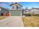 Charming two-story home boasts a well-manicured lawn, complemented by a green two-car garage and stone accents at 5051 Yates Cir, Broomfield, CO 80020