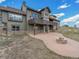 Back of house with patio, stone firepit, and walkout basement at 1660 Prominence Cir, Elizabeth, CO 80107