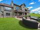 Spacious backyard with a large patio, fire pit, and well-manicured lawn, perfect for outdoor entertaining at 1660 Prominence Cir, Elizabeth, CO 80107