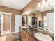 Elegant bathroom with double sinks, a dark countertop, and detailed wallpaper, offering a luxurious feel at 1660 Prominence Cir, Elizabeth, CO 80107