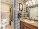 Unique bathroom with blue plaid wallpaper, a sink, and a shower/tub combination, showcasing a distinctive style at 1660 Prominence Cir, Elizabeth, CO 80107