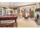 A relaxing game room features a pool table, comfortable seating, a fireplace, and large bright windows at 1660 Prominence Cir, Elizabeth, CO 80107