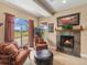 A bright living room with a stone fireplace, cozy seating, and patio access offering views of the outdoors at 1660 Prominence Cir, Elizabeth, CO 80107