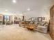 Spacious carpeted living room featuring a large sectional sofa and unique wood coffee table, perfect for relaxation at 1660 Prominence Cir, Elizabeth, CO 80107