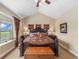 Luxurious primary bedroom featuring tray ceilings, a large bed, and ample natural light from the window at 1660 Prominence Cir, Elizabeth, CO 80107