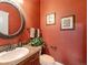 Charming powder room with patterned wallpaper, a decorative mirror, and a well-placed sink at 1660 Prominence Cir, Elizabeth, CO 80107