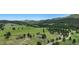 Expansive aerial view of two homes on a lush, green property surrounded by trees and rolling hills at 6880 Kilimanjaro Dr, Evergreen, CO 80439