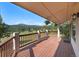 Relax on the spacious back deck with views of lush greenery and mountains at 6880 Kilimanjaro Dr, Evergreen, CO 80439
