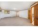 Finished basement featuring neutral carpet, natural wood trim, and large window for natural light at 6880 Kilimanjaro Dr, Evergreen, CO 80439