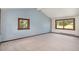 Spacious bedroom with vaulted ceiling, carpeted floors, and large windows with scenic views at 6880 Kilimanjaro Dr, Evergreen, CO 80439