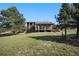 Exterior view of house surrounded by green grass and mature trees at 6880 Kilimanjaro Dr, Evergreen, CO 80439