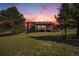 Lovely home with a wooden porch surrounded by trees and an open field at 6880 Kilimanjaro Dr, Evergreen, CO 80439