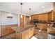 Bright kitchen with wood cabinets, granite island, stainless steel appliances, and recessed lighting at 6880 Kilimanjaro Dr, Evergreen, CO 80439