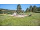 Gathering-friendly playground in a grassy area, featuring swings, a climbing dome, and benches at 6880 Kilimanjaro Dr, Evergreen, CO 80439