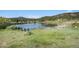 Tranquil pond with seating overlooking the water, surrounded by lush greenery and trees, offering a serene escape at 6880 Kilimanjaro Dr, Evergreen, CO 80439