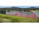 Outdoor tennis court surrounded by lush greenery and distant mountains, perfect for recreational activities at 6880 Kilimanjaro Dr, Evergreen, CO 80439