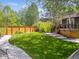 Charming backyard featuring a lush lawn, wooden fence, and inviting deck, perfect for outdoor relaxation and entertaining at 1333 W Peakview Ave, Littleton, CO 80120