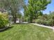 Spacious backyard featuring grass, landscaping, and a stone firepit at 1333 W Peakview Ave, Littleton, CO 80120