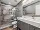 Modern bathroom featuring a double vanity, sleek fixtures, and a glass-enclosed shower with mosaic tile accents at 1333 W Peakview Ave, Littleton, CO 80120