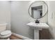 Bathroom featuring a round mirror above a pedestal sink and toilet at 1333 W Peakview Ave, Littleton, CO 80120