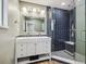 Bathroom with a dual sink vanity, modern fixtures, and a glass-enclosed shower with blue tiling at 1333 W Peakview Ave, Littleton, CO 80120