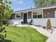 Inviting home exterior with a manicured lawn, updated windows, a unique door, and artistic front yard decor at 1333 W Peakview Ave, Littleton, CO 80120