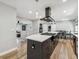 This kitchen offers an expansive island with cooktop, modern lighting, and stainless appliances at 1333 W Peakview Ave, Littleton, CO 80120