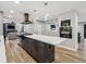 Open kitchen features a spacious island with cooktop, modern appliances, and access to the living room at 1333 W Peakview Ave, Littleton, CO 80120