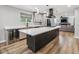 Open kitchen with quartz countertops, island with wine fridge, and view into living room at 1333 W Peakview Ave, Littleton, CO 80120