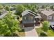 An aerial view showcasing a well-maintained home with a large yard and mature trees at 9698 Queenscliffe Dr, Highlands Ranch, CO 80130