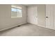 Bedroom featuring a large window providing ample light, sliding closet door, and neutral carpet at 9698 Queenscliffe Dr, Highlands Ranch, CO 80130