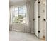 A bedroom view includes a large window with a view, neutral carpet, and an ensuite bathroom at 9698 Queenscliffe Dr, Highlands Ranch, CO 80130