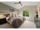 Comfortable bedroom with vaulted ceiling, stylish decor, and a large window overlooking the trees at 9698 Queenscliffe Dr, Highlands Ranch, CO 80130