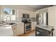 Well-lit kitchen with white cabinets, stainless steel appliances, and a functional island, great for cooking at 9698 Queenscliffe Dr, Highlands Ranch, CO 80130