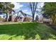 Expansive backyard with lush lawn, mature trees, and outdoor seating, perfect for enjoying the outdoors at 7082 W Morraine Dr, Littleton, CO 80128