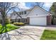 Charming home showcasing a well-manicured lawn, brick accents, and an attached two-car garage at 7082 W Morraine Dr, Littleton, CO 80128