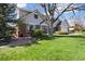Beautifully landscaped front yard, mature tree, and charming exterior of the home at 7082 W Morraine Dr, Littleton, CO 80128