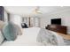 Serene main bedroom showcasing plush bedding, hardwood floors, and ceiling fan at 7082 W Morraine Dr, Littleton, CO 80128