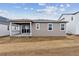 Back of the house with a covered porch, siding and a yard area prepped for landscaping at 19110 E 96Th Pl, Commerce City, CO 80022