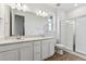 Elegant bathroom with double sinks, sleek white cabinets, and glass-enclosed shower at 19110 E 96Th Pl, Commerce City, CO 80022