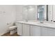 Modern bathroom with a double vanity, white cabinets, quartz counters, and a walk-in shower at 19110 E 96Th Pl, Commerce City, CO 80022
